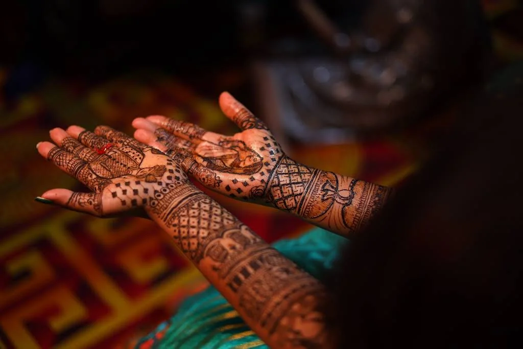 Intricate mehndi on open hands photographed in warm, soft light